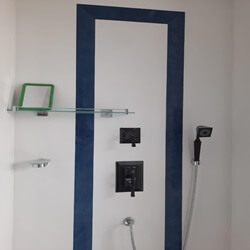 The image showcases a modern bathroom setup featuring sleek fixtures and a blue accent wall. 